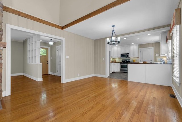 220 Porters Bluff Rd, Clarksville, TN 37040 - unfurnished living room with a chandelier, light wood finished floors, beam ceiling, and healthy amount of natural light