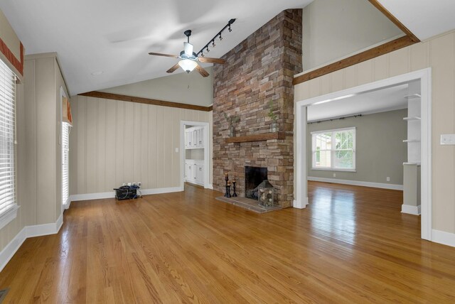 220 Porters Bluff Rd, Clarksville, TN 37040 - unfurnished living room with a ceiling fan, light wood finished floors, a stone fireplace, high vaulted ceiling, and baseboards