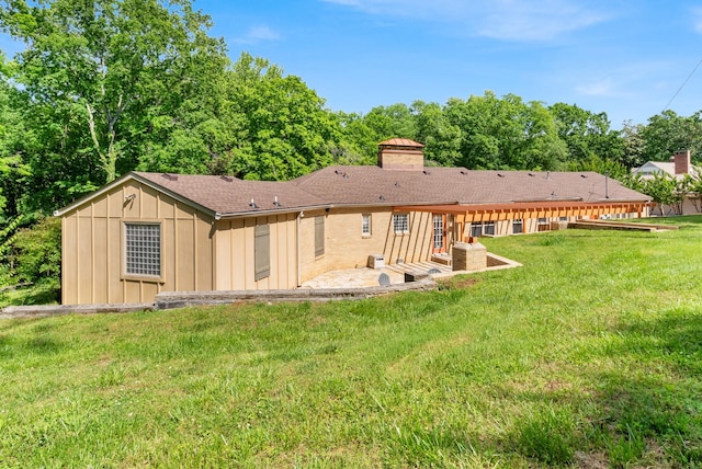 220 Porters Bluff Rd, Clarksville, TN 37040 - back of property with a chimney, a patio, board and batten siding, a yard, and a shingled roof