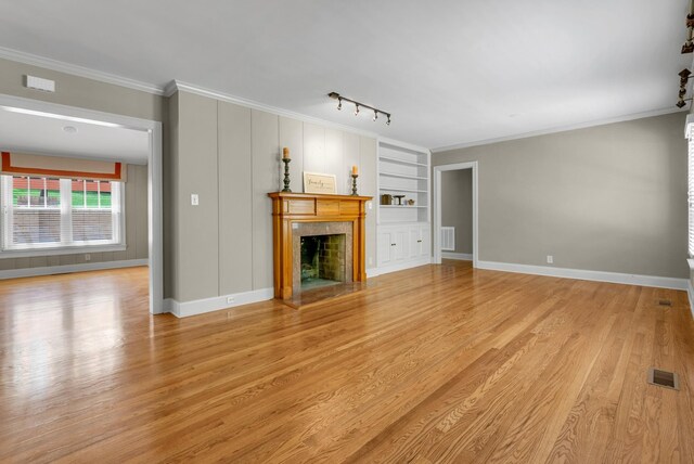 220 Porters Bluff Rd, Clarksville, TN 37040 - unfurnished living room featuring a premium fireplace, light wood-type flooring, built in features, baseboards, and ornamental molding