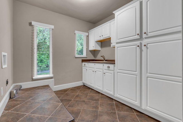 220 Porters Bluff Rd, Clarksville, TN 37040 - laundry area with cabinet space, baseboards, and dark tile patterned floors