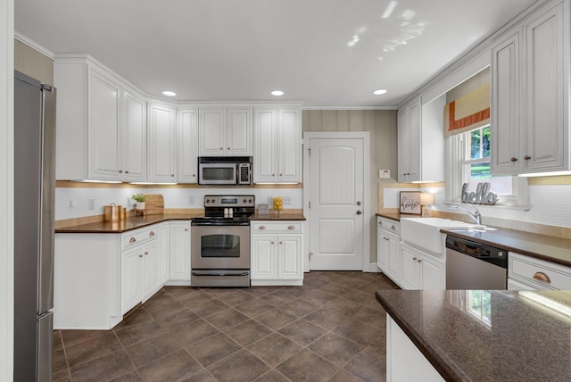 220 Porters Bluff Rd, Clarksville, TN 37040 - kitchen with appliances with stainless steel finishes, a sink, recessed lighting, white cabinets, and backsplash