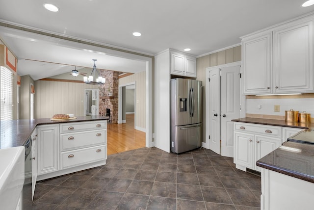 220 Porters Bluff Rd, Clarksville, TN 37040 - kitchen featuring stainless steel fridge with ice dispenser, dark countertops, a chandelier, white cabinets, and wooden walls