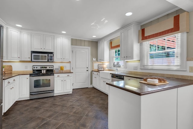 220 Porters Bluff Rd, Clarksville, TN 37040 - kitchen with stainless steel appliances, a sink, recessed lighting, white cabinetry, and a peninsula