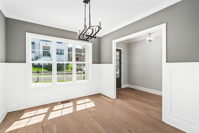 129 Barlow Dr, Franklin, TN 37064 - unfurnished dining area with a chandelier, crown molding, wood finished floors, wainscoting, and a decorative wall