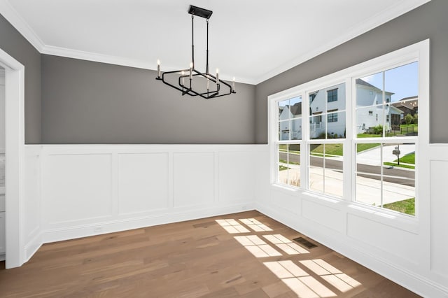 129 Barlow Dr, Franklin, TN 37064 - unfurnished dining area featuring a chandelier, ornamental molding, healthy amount of natural light, a decorative wall, and wood finished floors