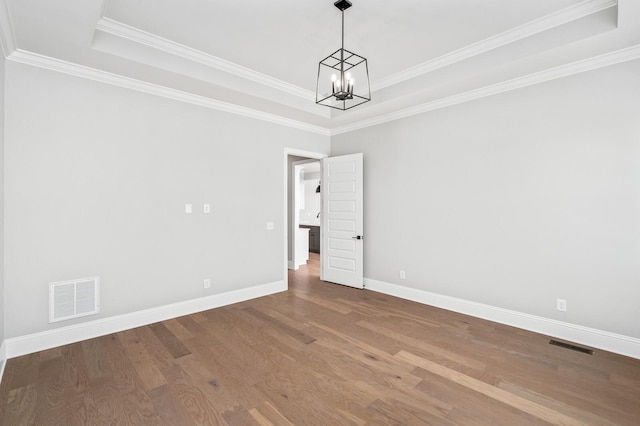 129 Barlow Dr, Franklin, TN 37064 - spare room with a chandelier, a raised ceiling, baseboards, wood finished floors, and crown molding