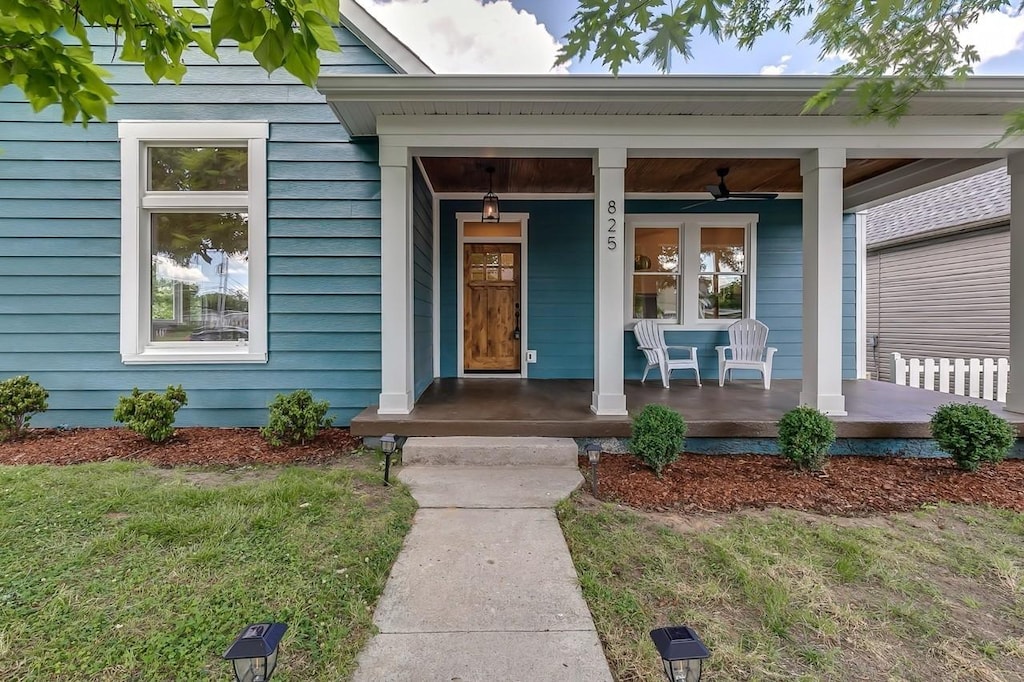 view of exterior entry featuring covered porch and ceiling fan