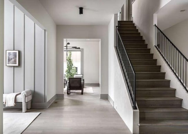stairs with wood finished floors and baseboards