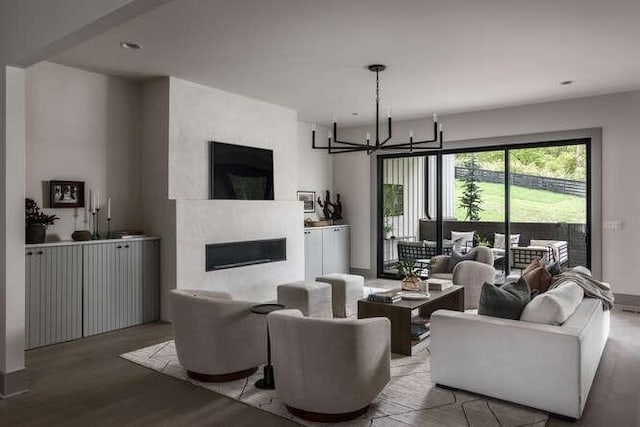 living area featuring a fireplace, wood finished floors, and a chandelier