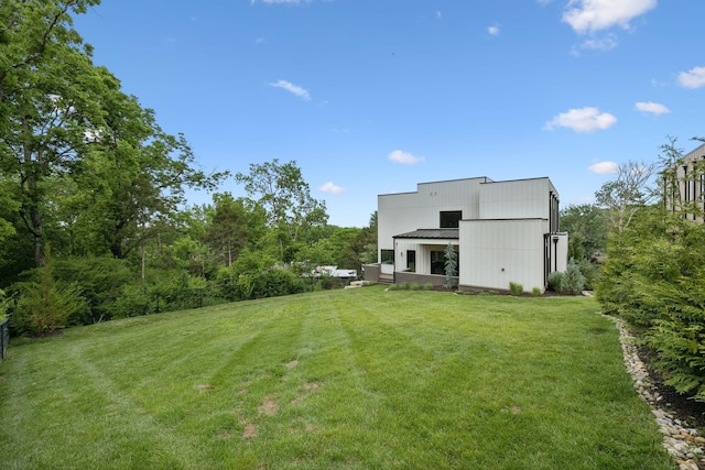 back of property with an outbuilding, a lawn, metal roof, and an outdoor structure