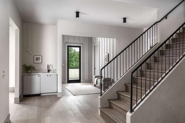 foyer featuring stairway, wood finished floors, and baseboards