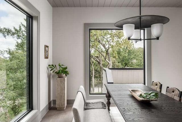 dining area featuring a chandelier, light wood-style flooring, healthy amount of natural light, and wood ceiling