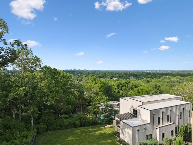 aerial view of property and surrounding area featuring a heavily wooded area