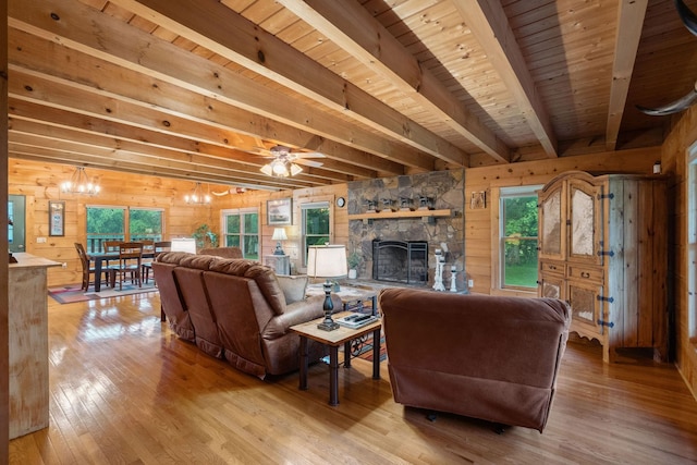 10120 Lascassas Pike, Lascassas, TN 37085 - living room featuring wood walls, light wood-style floors, wood ceiling with exposed beams, a stone fireplace, and a chandelier