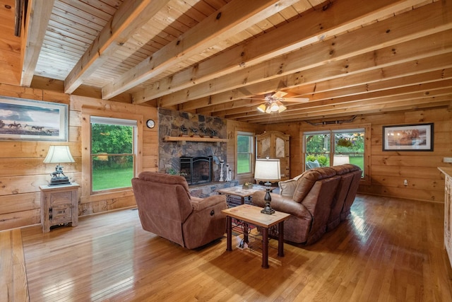 10120 Lascassas Pike, Lascassas, TN 37085 - living area featuring wooden walls, light wood-type flooring, a fireplace, ceiling fan, and wood ceiling with exposed beams