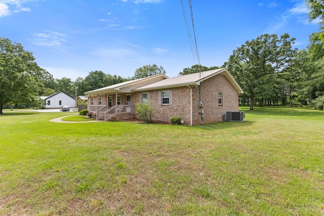 111 Hickory Trce, Lyles, TN 37098 - view of front facade with central AC, a porch, brick siding, and a front lawn