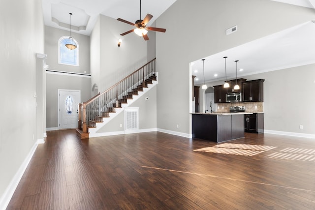 201 Josie Ln, Clarksville, TN 37043 - unfurnished living room featuring a high ceiling, dark wood-type flooring, a ceiling fan, stairway, and baseboards