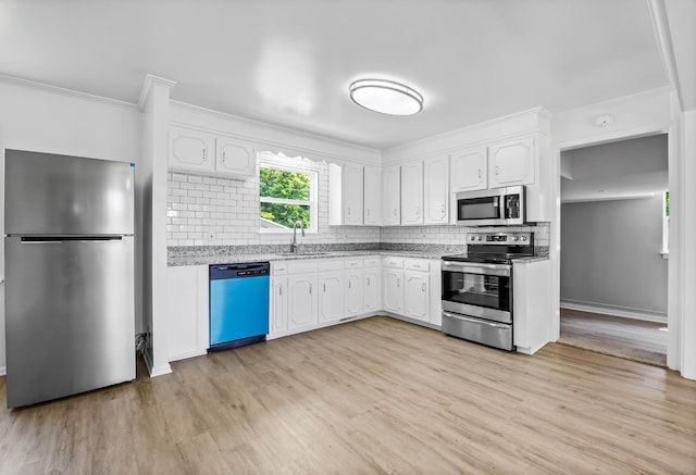 2705 Thrush Dr, Clarksville, TN 37040 - kitchen with appliances with stainless steel finishes, white cabinets, decorative backsplash, light wood-style flooring, and crown molding