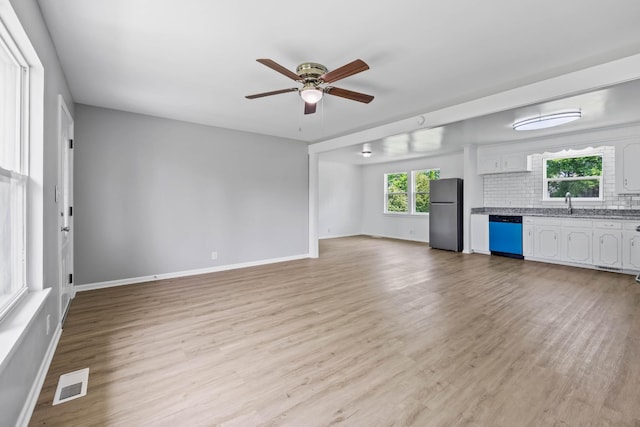 2705 Thrush Dr, Clarksville, TN 37040 - unfurnished living room featuring ceiling fan, light wood-style flooring, baseboards, and a sink