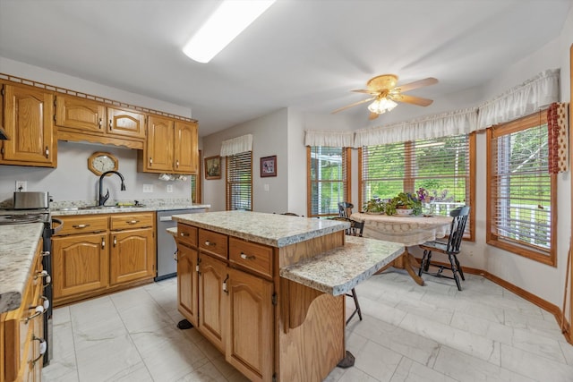 kitchen featuring light marble finish flooring, a sink, a kitchen island, and ceiling fan