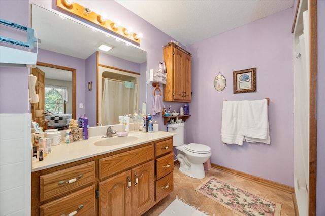 bathroom featuring vanity, toilet, baseboards, a shower with shower curtain, and tile patterned floors