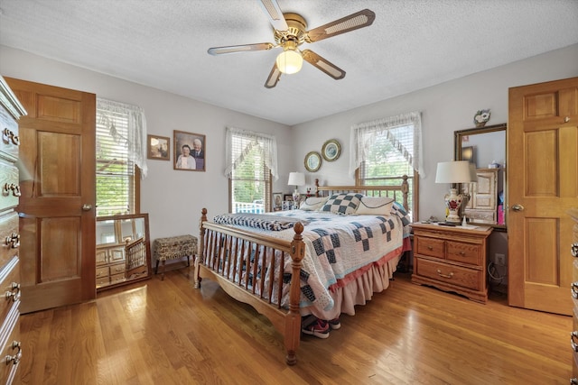 bedroom featuring a textured ceiling, light wood-type flooring, and ceiling fan