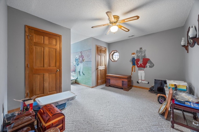 rec room with carpet, a ceiling fan, a textured ceiling, and baseboards