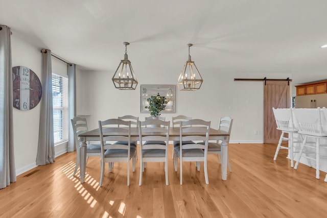 1032 Neeleys Bnd, Spring Hill, TN 37174 - dining area with light wood-style flooring, a barn door, baseboards, and a chandelier
