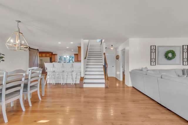 1032 Neeleys Bnd, Spring Hill, TN 37174 - living room with a barn door, light wood-style flooring, stairway, baseboards, and recessed lighting