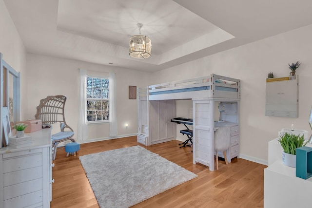 1032 Neeleys Bnd, Spring Hill, TN 37174 - bedroom featuring a tray ceiling, an office area, a chandelier, and light wood-style flooring