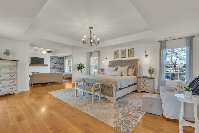 1032 Neeleys Bnd, Spring Hill, TN 37174 - bedroom featuring a tray ceiling, light wood-type flooring, a chandelier, and multiple windows