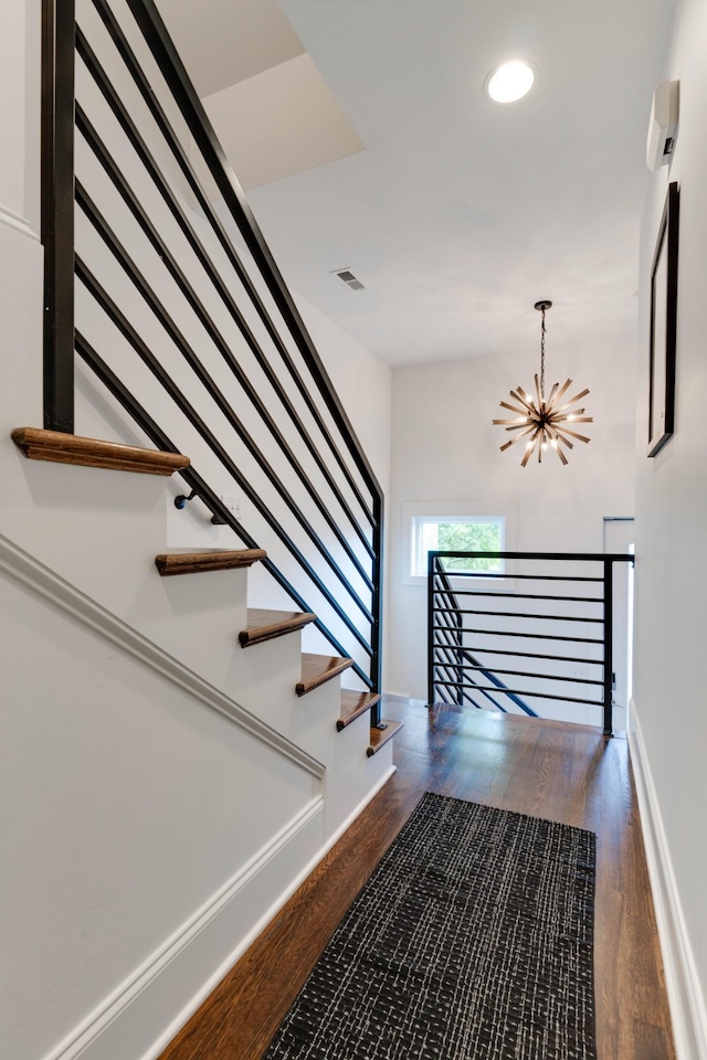 stairway featuring a chandelier, wood finished floors, recessed lighting, and baseboards