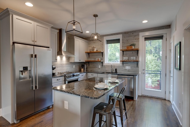 kitchen with high quality appliances, wall chimney range hood, open shelves, tasteful backsplash, and recessed lighting