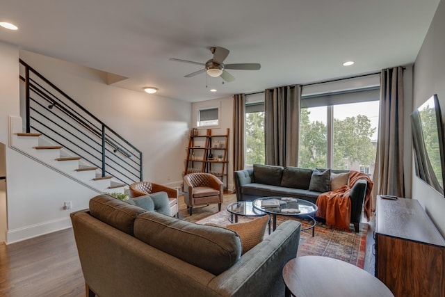 living area with a ceiling fan, stairway, wood finished floors, baseboards, and recessed lighting
