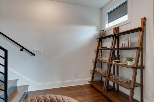 staircase featuring wood finished floors and baseboards