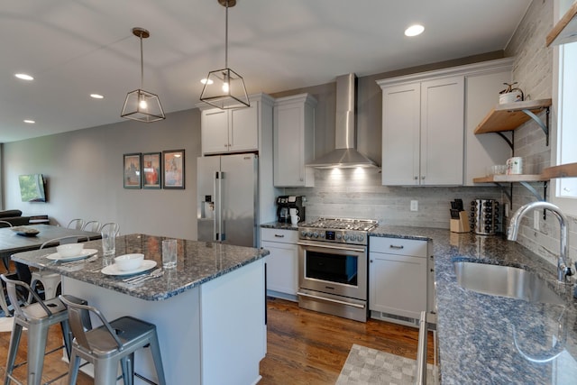 kitchen featuring high end appliances, open shelves, wall chimney range hood, a sink, and dark wood-style floors