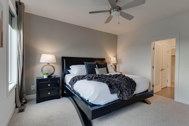 bedroom with light carpet, baseboards, and a ceiling fan