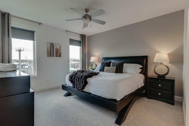 bedroom featuring light carpet, baseboards, and a ceiling fan