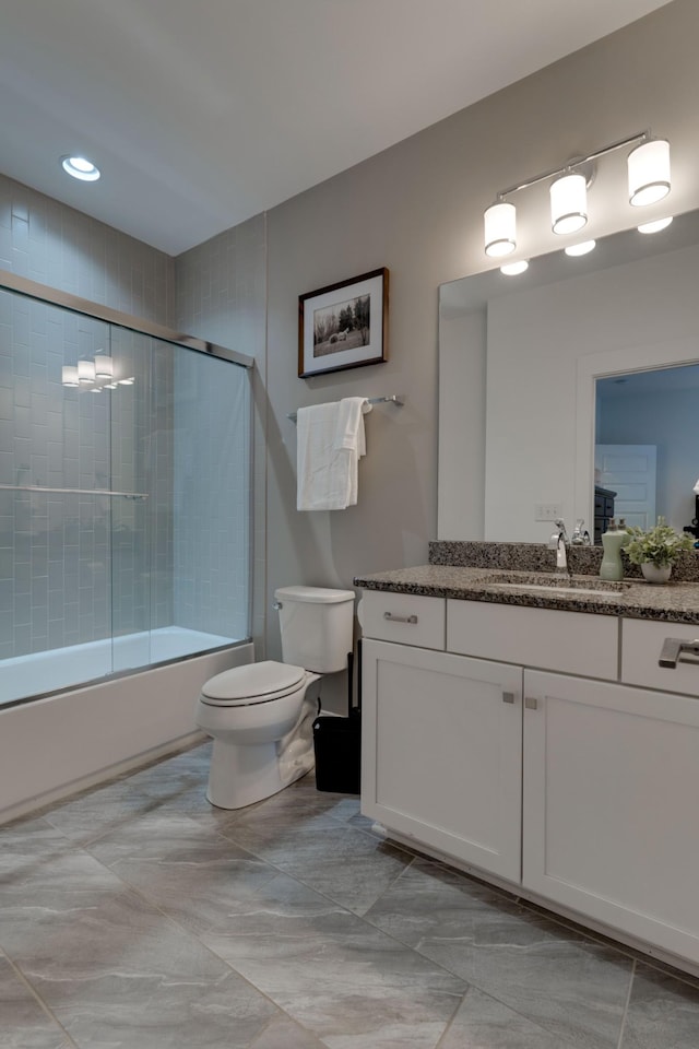 bathroom featuring toilet, vanity, and shower / bath combination with glass door