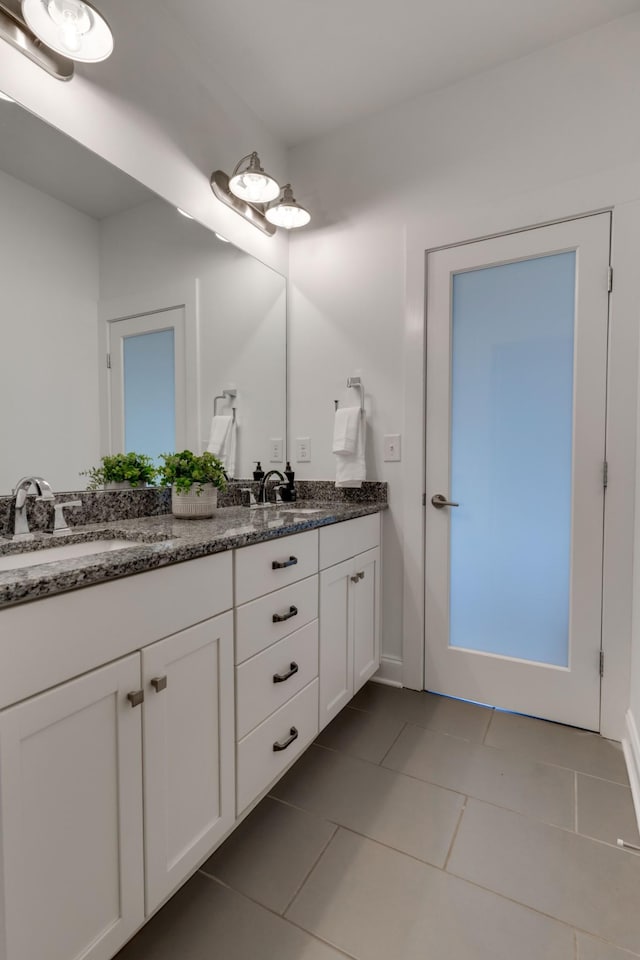 bathroom with tile patterned flooring, double vanity, and baseboards