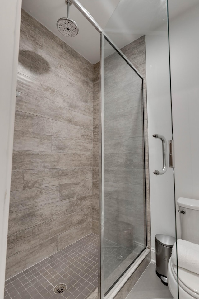 full bath featuring a stall shower and toilet