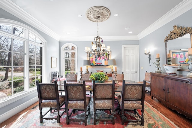 dining area with a chandelier, wood finished floors, ornamental molding, and recessed lighting