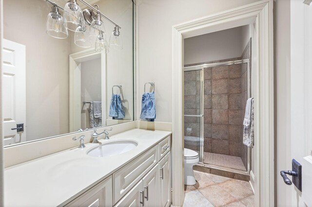 bathroom featuring toilet, a shower stall, vanity, and tile patterned floors