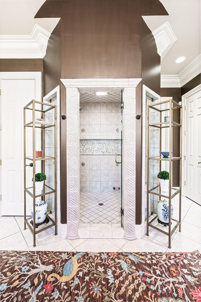 bathroom featuring tile patterned floors, crown molding, and a shower stall