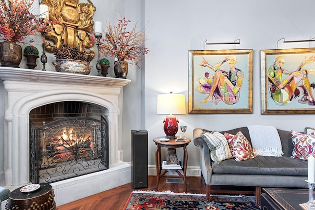living room featuring wood finished floors and a lit fireplace