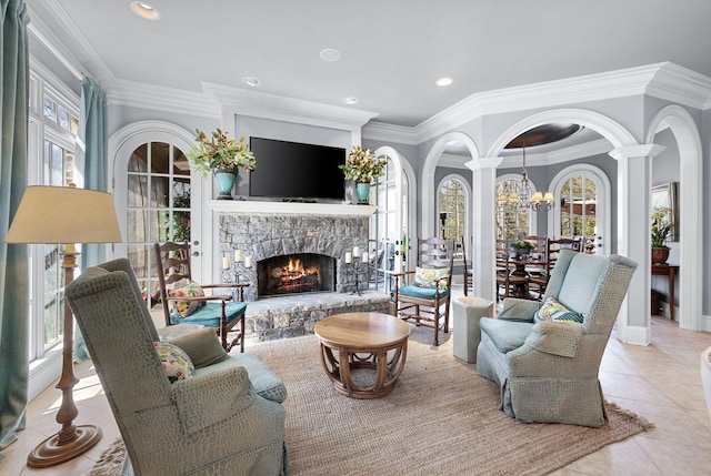 living room with healthy amount of natural light, a fireplace, tile patterned flooring, ornamental molding, and a chandelier