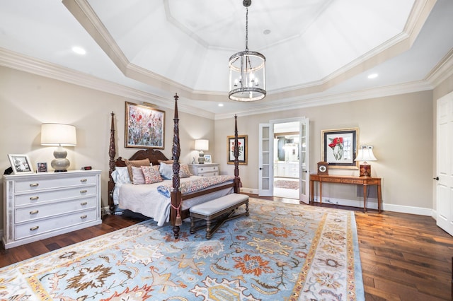 bedroom featuring a chandelier, a tray ceiling, ornamental molding, dark wood-type flooring, and baseboards