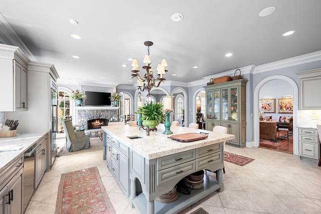 kitchen featuring gray cabinetry, open floor plan, a stone fireplace, recessed lighting, and light tile patterned floors