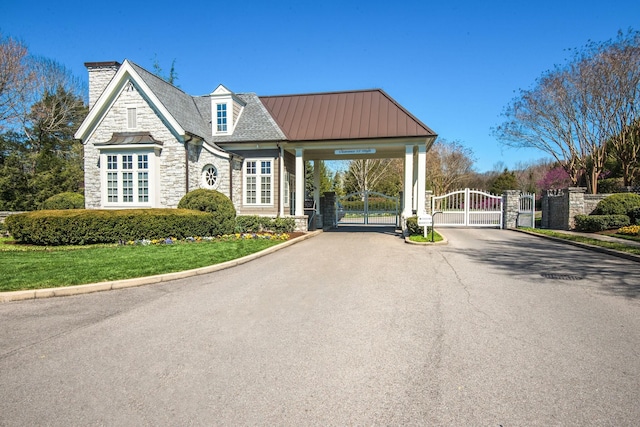 view of asphalt road with a gate, curbs, and a gated entry